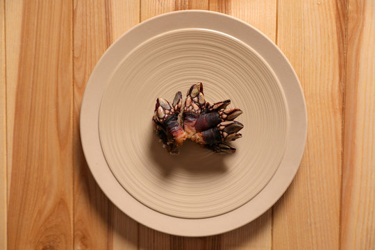 Fresh goose barnacle on wooden table, top view