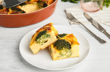 Tasty broccoli casserole served on white wooden table