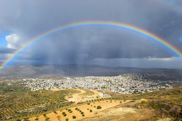rainbow over the arab village Cana of Galilee ( Kafr Kanna ) in Israel , place where Christ showed first miracle - obrazy, fototapety, plakaty