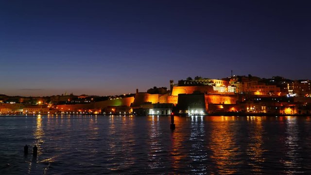City lights of Valletta in Malta with reflection the Grand Harbour at night