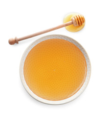 Bowl of organic honey and dipper isolated on white, top view