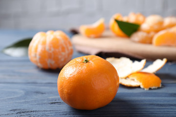 Fresh ripe tangerine on blue wooden table