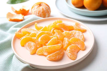 Fototapeta na wymiar Segments of fresh ripe tangerines on white table