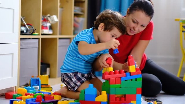 mother playing colorful plastic blocks toy with her son, concept for mother and son playing together.