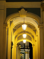 Naklejka premium cascade of several arches illuminated by yellow street lamps