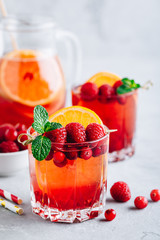 Raspberry Cranberry Sangria Punch or Mojito in glass with orange slices and mint