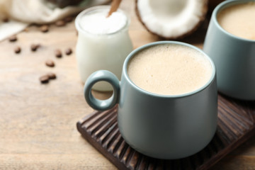 Delicious coffee with organic coconut oil on wooden table