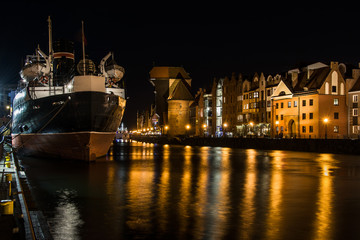 Fototapeta na wymiar Old town of Gdansk with ancient crane at night, ship, Poland