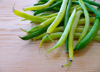 Green and yellow bean pods of asparagus on old rustic wooden table. Freshly harvested raw beans on wooden background. Closeup, selective focus.