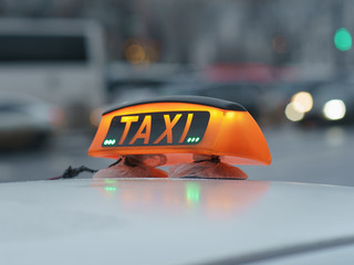 Photography of city taxi in the snowy winter day. Image with defocused background. Suitable for posters, greeting card.