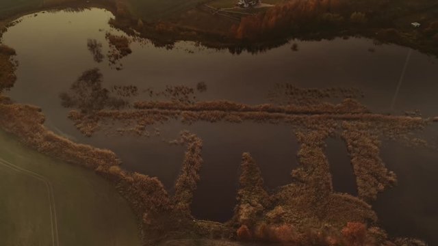 Small lake at Warmia-Masuria region in Poland at sunset. Drone, aerial footage.