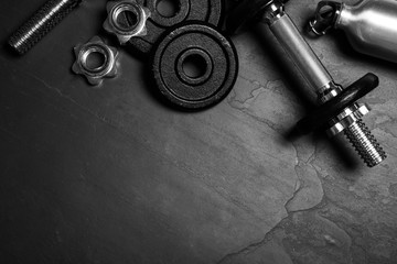 Gym equipment on black background, flat lay. Space for text