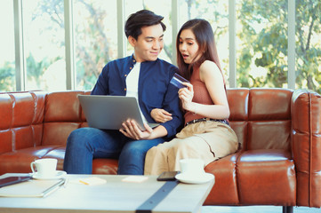 Portrait of cute sweet couple spending time together indoor, in house, apartment sitting on sofa looking to the side. Pleasure enjoyment delight recreation concept