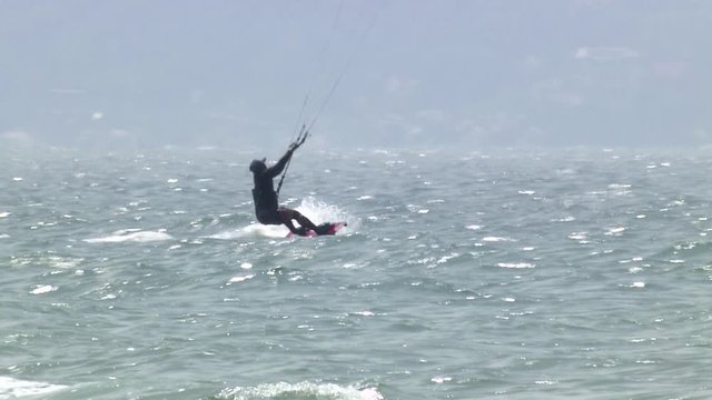 Kite surfer ride the wave and jump 