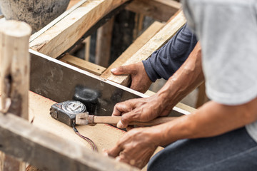 carpenter working at site construction. Measuring Tape on wood board.
