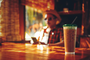 Ice coffee is on the table in coffee shop and light of sun at summer.