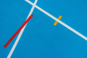 Blue running track with white lines, yellow and red mark in sport stadium. Top view