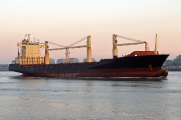 Naklejka premium Feederschiff morgens bei der Einfahrt in den Hafen