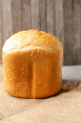 Wheat bread, white. On the table lies a loaf of white bread, slices of bread. Close-up.