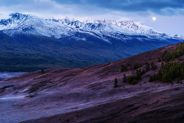 The moon over the North Chuysky ridge, the tract Eshtykel before dawn. Russia, mountain Altai