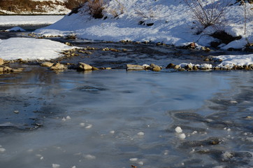 winter landscape in the forest with snow and blue sky and river