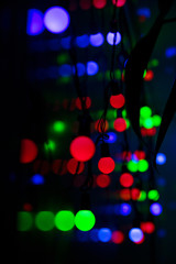 Multi-colored glare from garlands in the form of abstraction in the dark