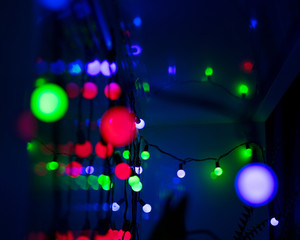 Multi-colored glare from garlands in the form of abstraction in the dark