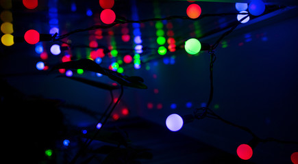 Multi-colored glare from garlands in the form of abstraction in the dark