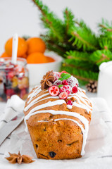 Traditional fruit cake with mixed fruit and cherries decorated with sugar icing, cranberries, pomegranate and cherry on a white background. Vertical orientation.