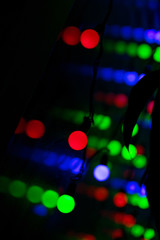 Multi-colored glare from garlands in the form of abstraction in the dark