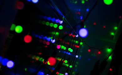 Multi-colored glare from garlands in the form of abstraction in the dark