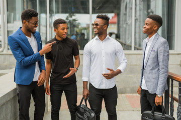 four young african men near the building in summer