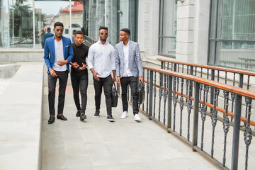 four young african men near the building in summer