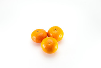  Three yellow tangerines on a big background.