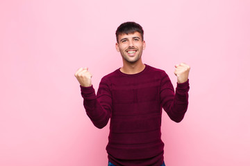 young handsome man celebrating an unbelievable success like a winner, looking excited and happy...