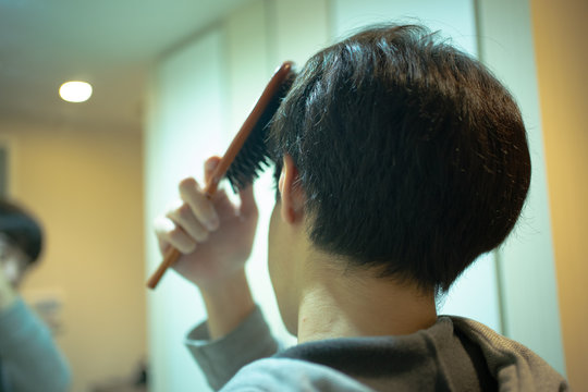 洗面所で髪を整える男性