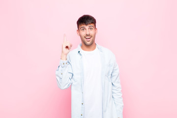 young handsome man feeling like a happy and excited genius after realizing an idea, cheerfully...
