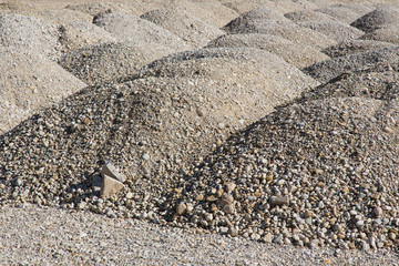 Garten- und Landschaftsbau: Berge aus Sand Kies und Steinen für den Bau von Wegen und Strassen