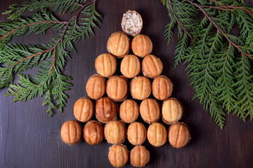 Walnut shaped cookies Oreshki forming a Christmas tree on the dark wooden background