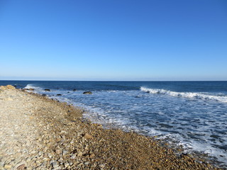Clear blue sky over the rocky beach at Montauk, Long Island, New York.