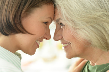 Close up portrait of senior woman with daughter at home