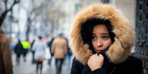 Girl in fur hood experiencing cold in the city (Madrid)