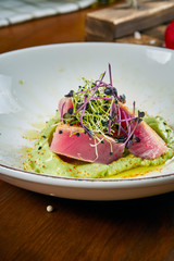Close up view on tasty Appetizing salad with fresh medium-rare grilled tuna, capers, cherry...