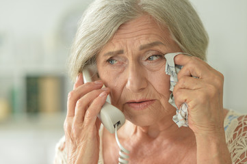 Close up portrait of upset senior woman calling doctor