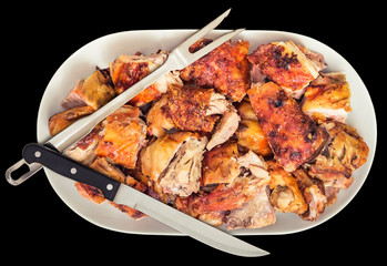 Freshly Spit Roasted Pork Thigh Meat Slices Offered on White Ceramic Porcelain Tray with Serving Knife and Fork Isolated on Black Background