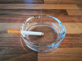 ashtray and cigarette on wooden table