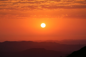 Landscape View of a sun during the sunset with orange background and Mountains