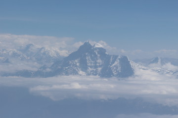 Fototapeta na wymiar A beautiful photo of a mountain with glacier and snow on it from a height above the clouds
