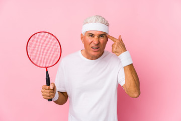 Naklejka premium Middle aged man playing badminton isolated showing a disappointment gesture with forefinger.