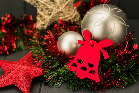 Christmas decoration with red velvet bell, glitter star, and silver balls on red and green tinsel - Powered by Adobe